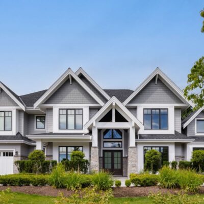 Striking front view of a traditional home with multiple A-frame peaks and bold black-and-white exterior, exuding timeless elegance and sophistication.