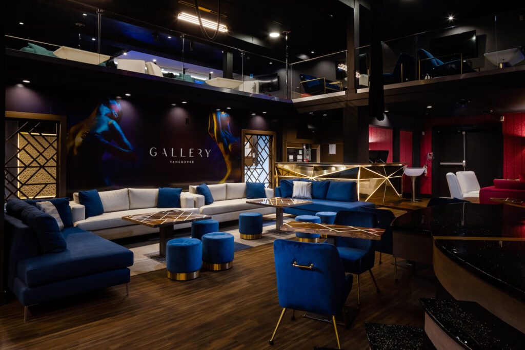 A stylish nightclub featuring electric blue chairs and stools, sleek couch-style banquette seating, and moody lighting that sets the perfect ambiance for an intimate and lively experience.