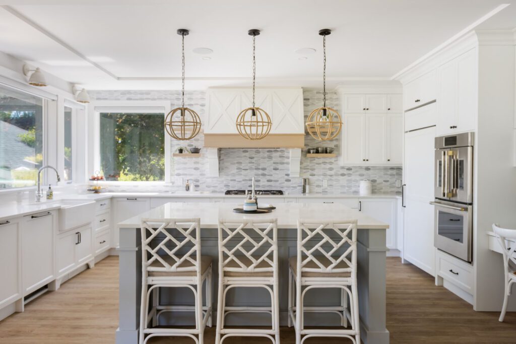 A newly renovated kitchen featuring a stylish island with bar seating, pendant lighting, and a sleek tile backsplash, combining modern design with functionality.
