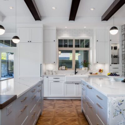 Side view of a beautifully renovated kitchen featuring dual islands, sleek cabinetry, and elegant finishes, designed for functionality and seamless connection to the greatroom.